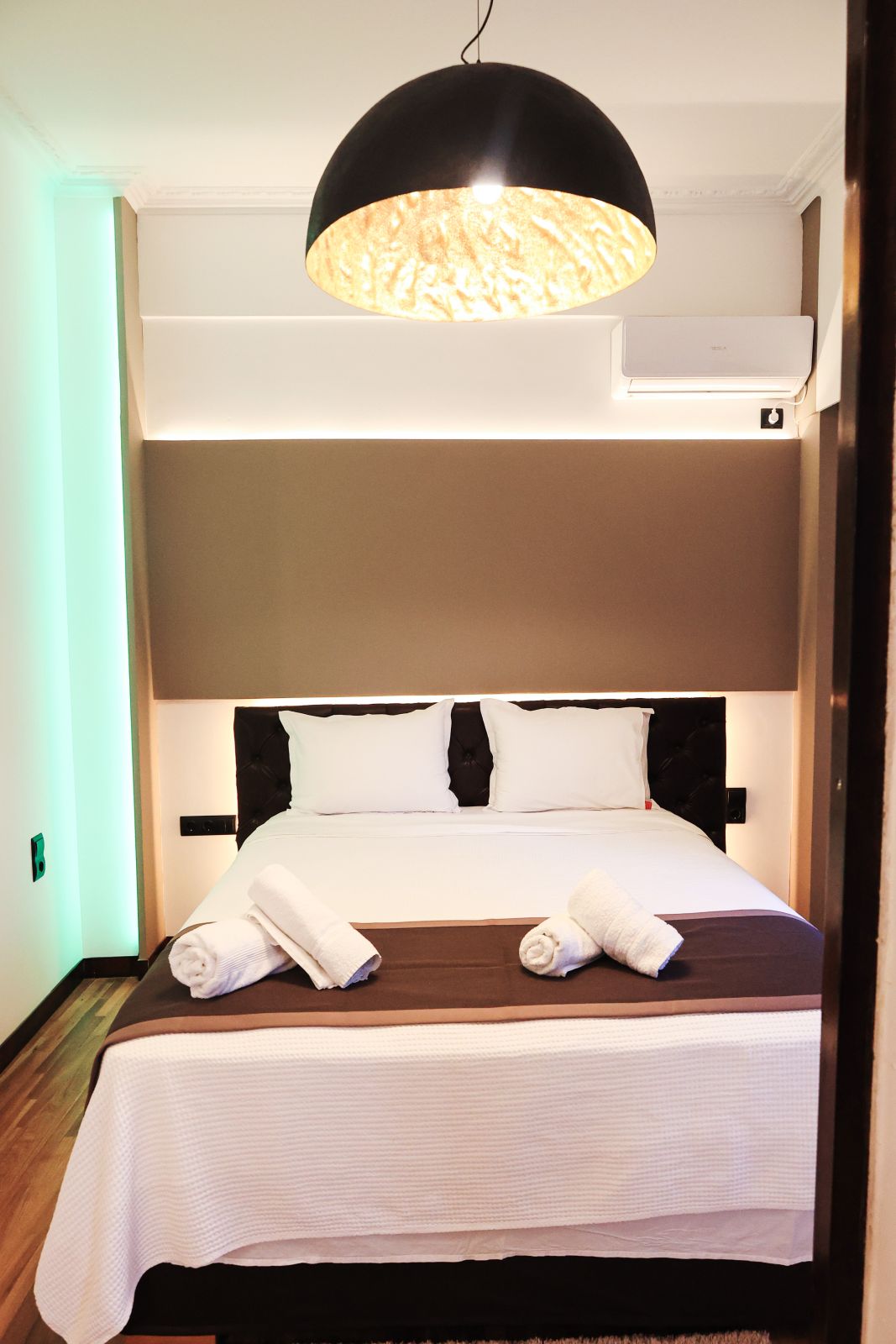 Double bed under the statement pendant light